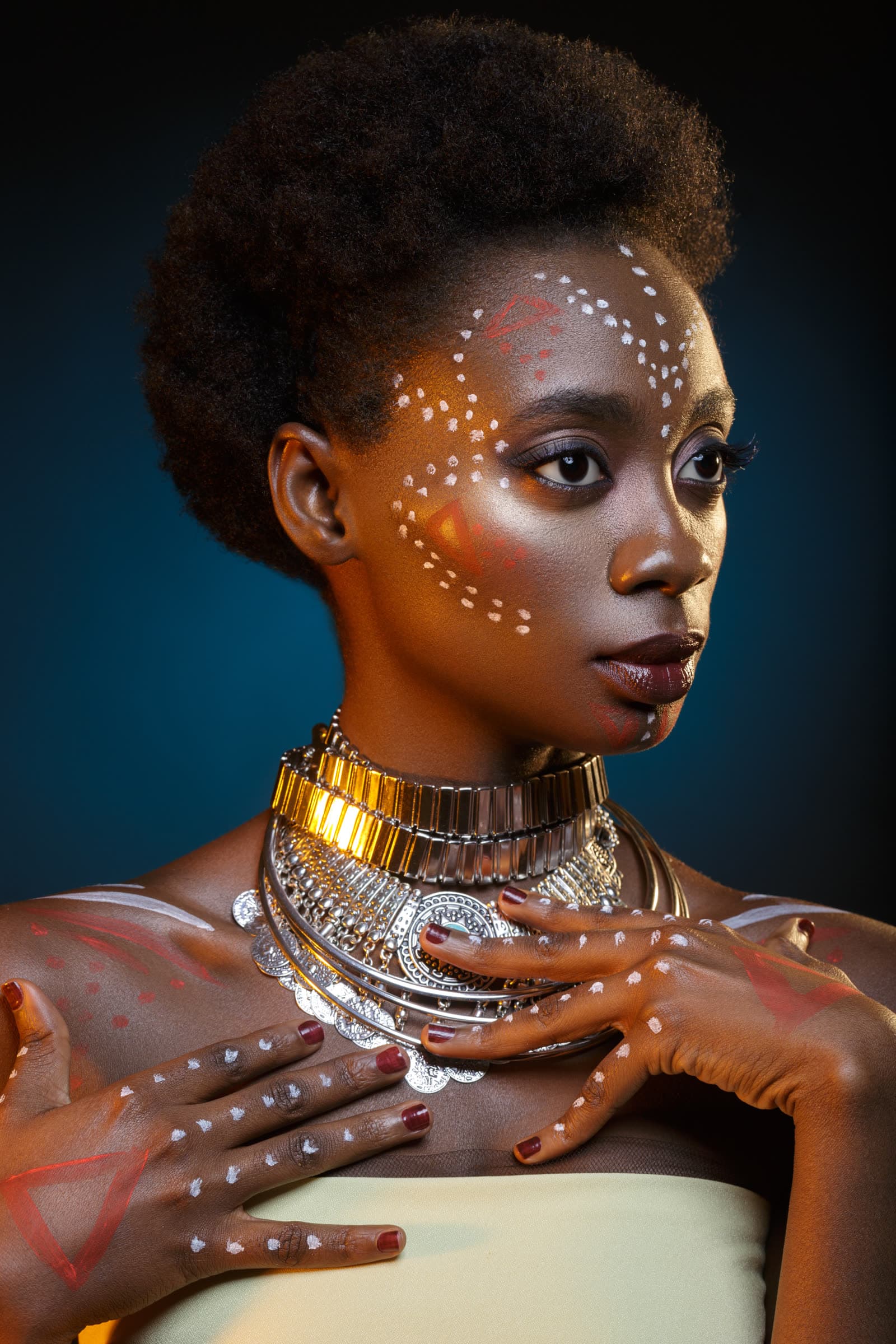 A woman in artistic face paint and jewellery